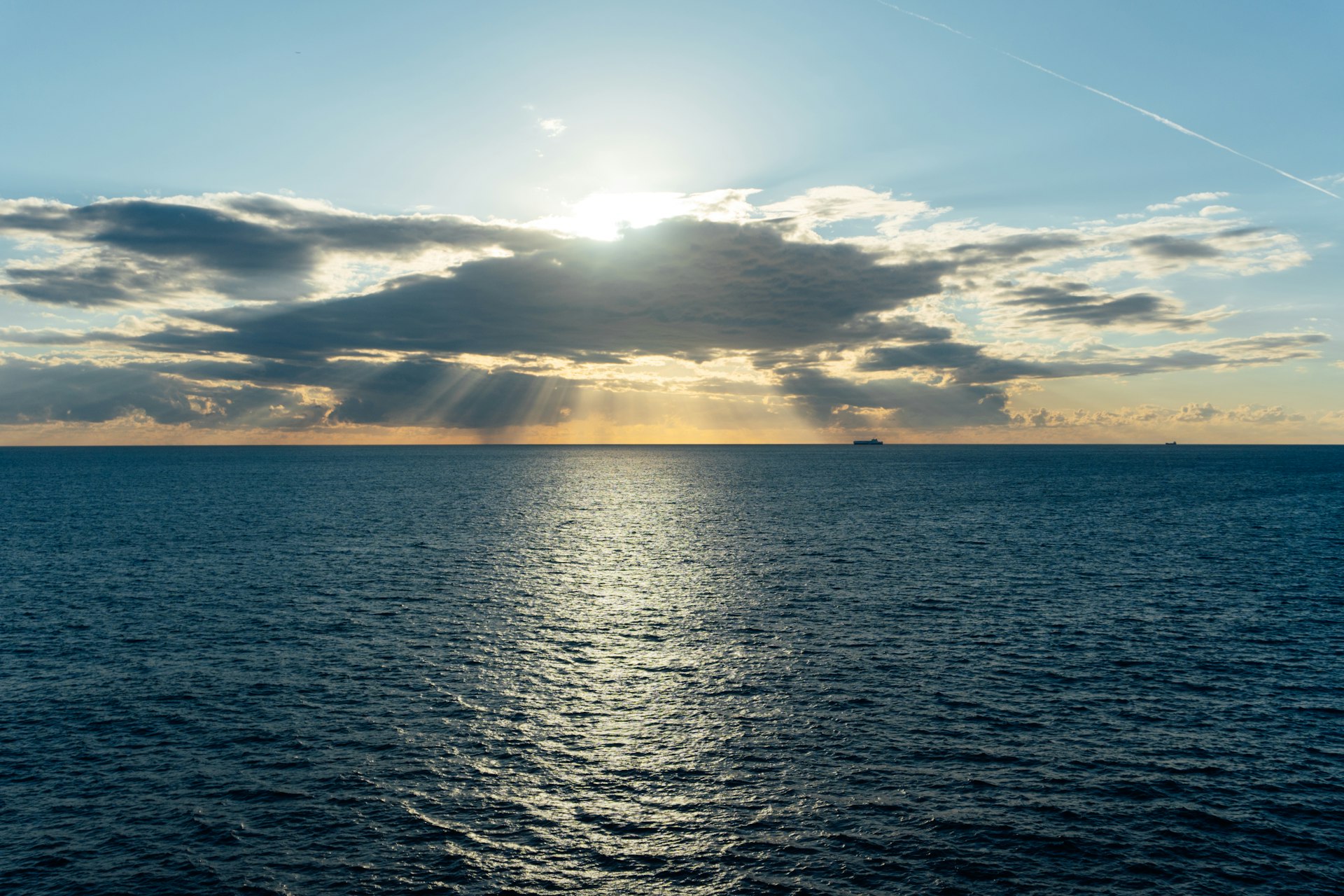 Sunlight breaking through clouds over the ocean.